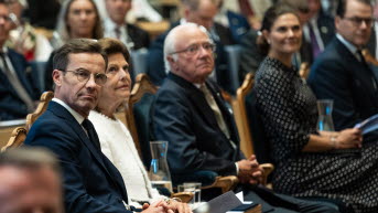 Fem personer - statsministern, kungaparet och kronprinsessparet - sitter med ansiktena vända åt höger.