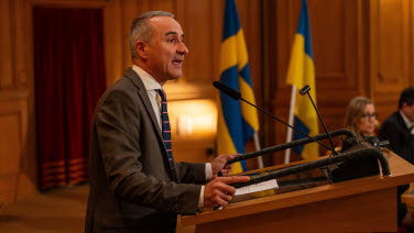 A man delivers a speech from the rostrum in the former Second Chamber.