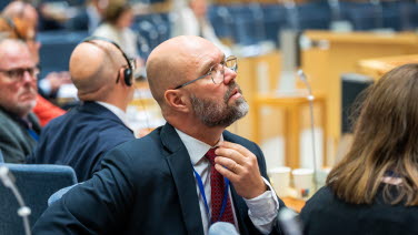 Man sitter i sin bänk och tittar upp.