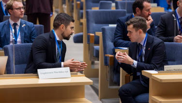 Sessionsdeltagare pratar med varandra i kammaren.