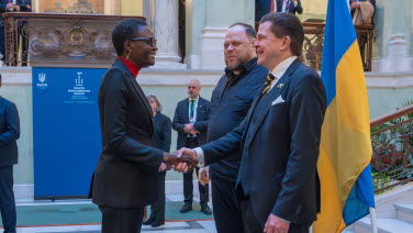 The two Speakers greet a woman.