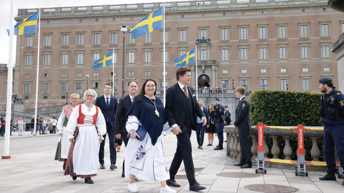 Talmannen, hans fru och de tre vice talmännen är på väg in till riksdagshuset. Slottet syns i bakgrunden.