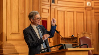Riksbankschef Erik Thedéen gestikulerar i talarstolen.