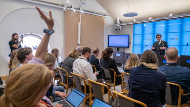 En journalist räcker upp handen i presscentret där talmannen håller presskonferens efter talmansrundan.