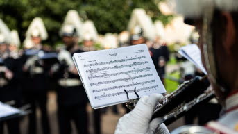 Ett notblad sett över axeln på en klarinettist. Noternas titel är "Sverige"