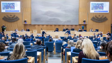 Magdalena Andersson (S) i debatt med Jimmie Åkesson (SD). I förgrunden flera ledamöter. 
