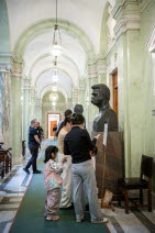 En familj med två vuxna och två barn tittar på en byst i Trapphallen.