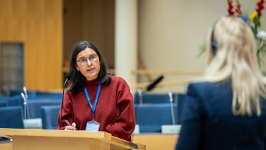 Två kvinnor debatterar med varandra. Den ena har ryggen mot kameran.