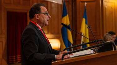 A man delivers a speech from the rostrum.