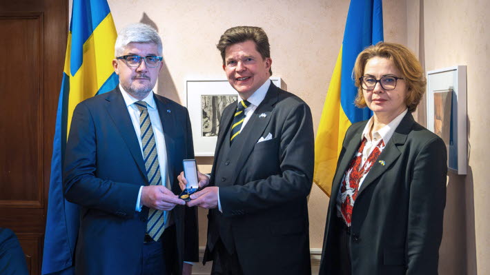Ukrainas ambassdör håller i medaljen han fått av talman Andreas Norlén. Till höger ambassadörens hustru.