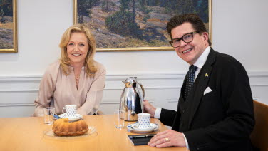 Partiledare Elisabeth Thand Ringqivst sitter jämte talmannen. På bordet finns kaffe och kaffekoppar.