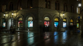 Utställningen i hörnet på kvällen med upplysta fönster. 