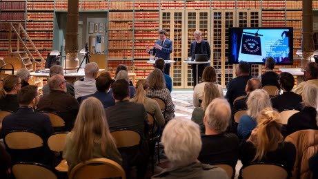 Talman Andreas Norlén står bakom ett podium i Riksdagsbiblioteket och talar inför en publik.