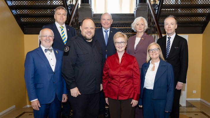 Gruppbild på åtta personer framför en trapp.
