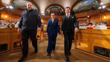 Two men and a woman on their way into the former Second Chamber.