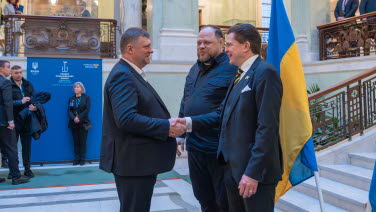 The two Speakers greet a man.