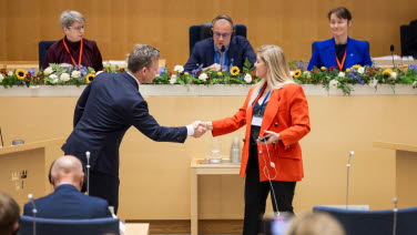 Två sessionsdeltagare tar i hand efter debatt