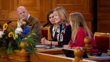 Fyra paneldeltagare sitter vid podiet i Förstakammarsalen.