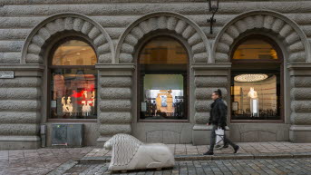 Skyltfönstren från gatan med ett betonglejon framför. 