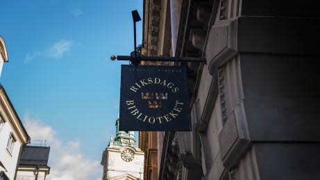 Ingången till Riksdagsbiblioteket på Storkyrkobrinken. I förgrunden en skylt med orden Riksdagsbiblioteket.